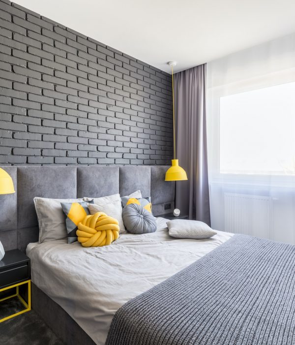 Real photo of grey and yellow bedroom interior with window with