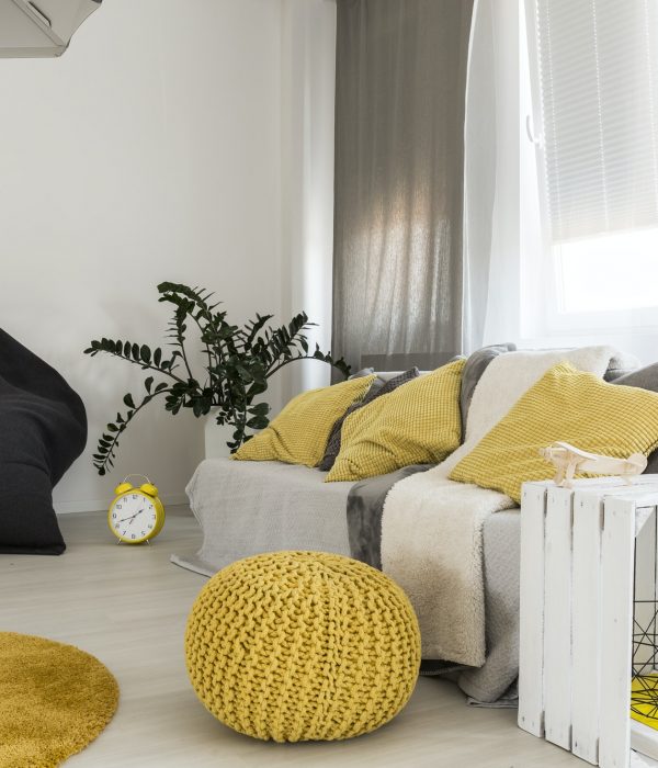 Room with couch and yellow pouf
