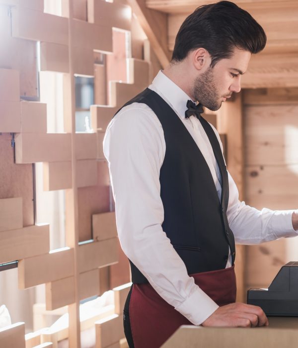 Waiter standing with credit card at cash register