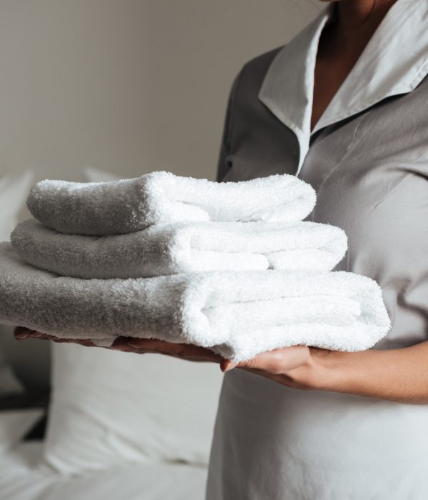 Young maid holding folded towels